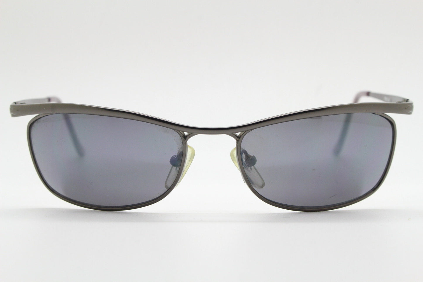 Y2K vintage curved oval sunglasses. Minimal grey chrome metal aerodynamic sport shaped frame. 2000's. 00's NOS