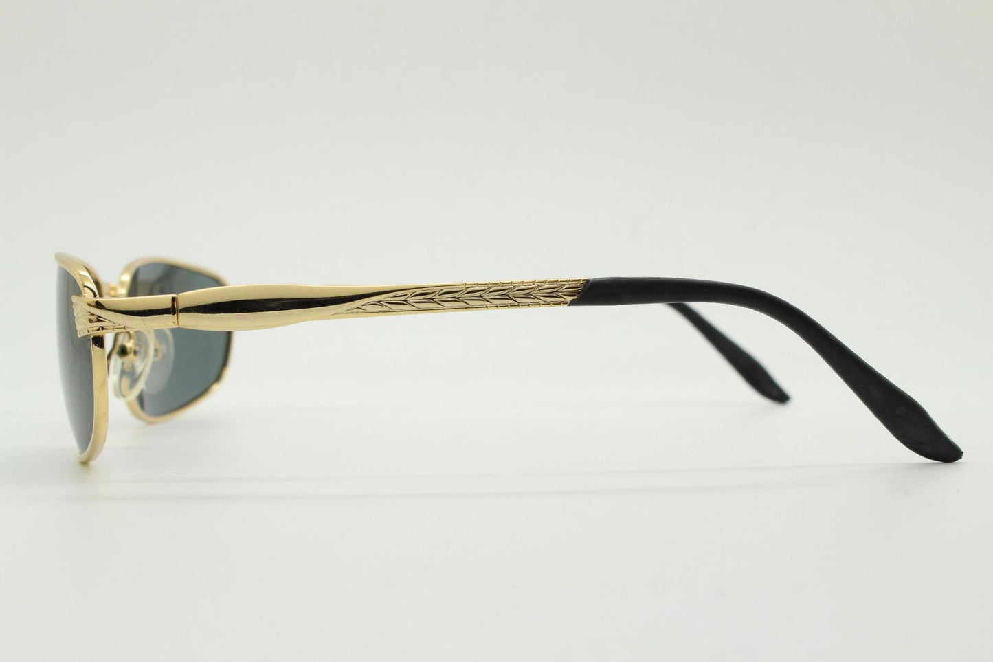 90s vintage low profile gold rectangular sunglasses. Solid metal frame in a shiny chrome finish embossed arm pattern and green lenses. NOS