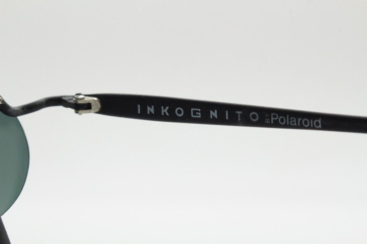 Inkognito 90s vintage small oval sunglasses. Matt finish half frame with spell out logo brow and polarising lenses. NOS