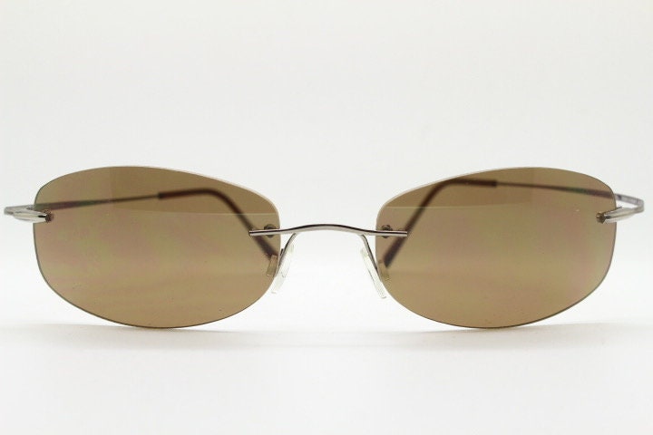 Faconnable 90s vintage sunglasses model 859 hand made in Italy. Minimal frameless design with flexible wire arms and brown chrome trim. NOS