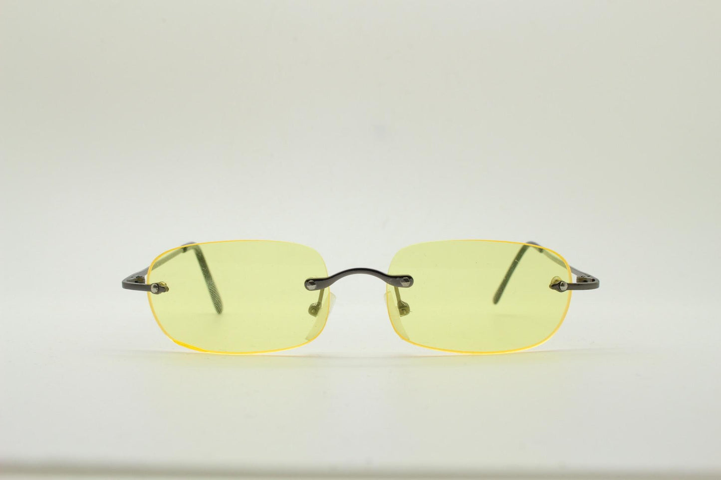 Y2K vintage frameless yellow sunglasses. Rectangular lenses with grey metal bridge and arms. 2000s club kids. 00's. 90s Rave