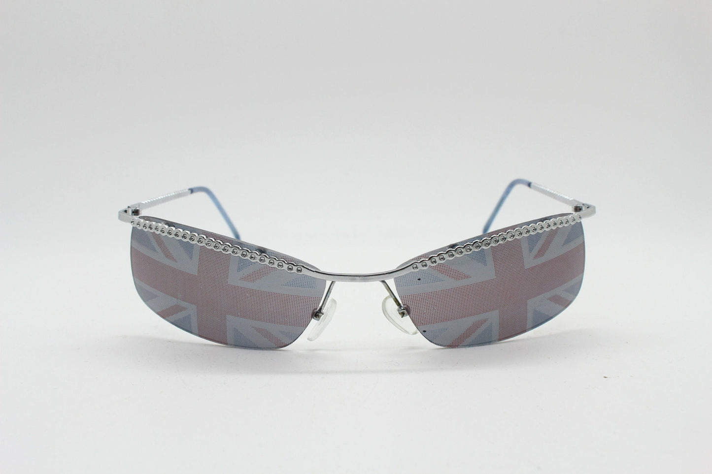 90s vintage half frame Union Jack sunglasses. Curved lens suspended on a sparkling chrome brow. Unused NOS. Brit pop girl power