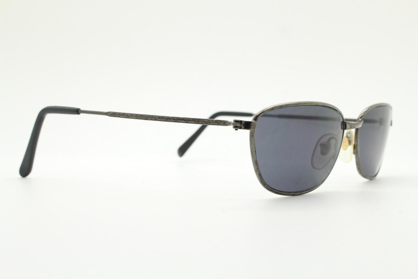 90s vintage angular pointed sunglasses. Minimal grey chrome metal frame with embossed patterned arms. Subtle cat eye. NOS