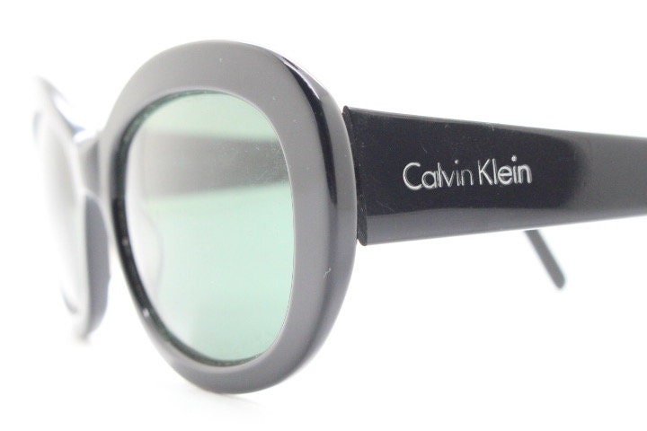 Calvin Klein vintage oval cateye sunglasses made in Italy. Womens plain black gloss thickened acetate cat eye. Classical 60s design. Y2K