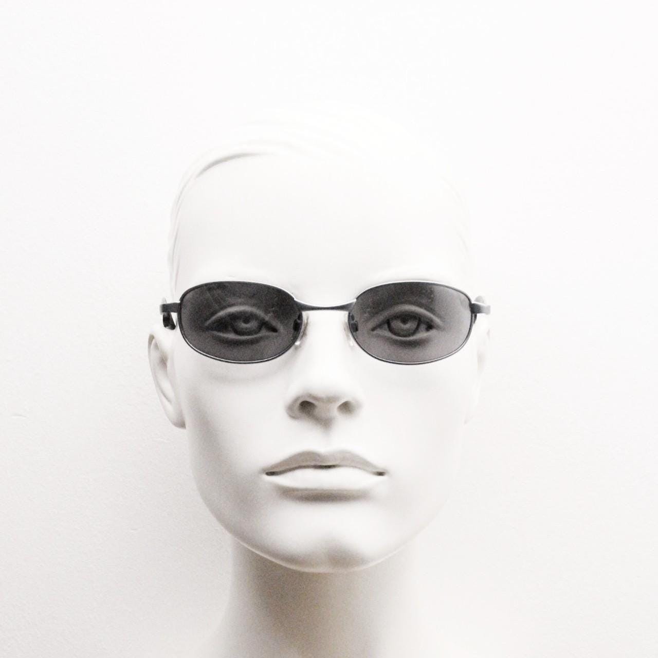 90s vintage oval small bug eye sunglasses. Curved blue satin finish solid metal frame with stylised arched arms and rubber ends. Unused NOS