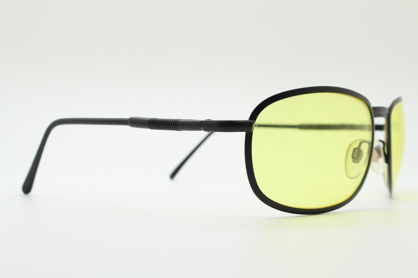 90s vintage oval bug eye sunglasses. Matt black metal frame with blazing yellow lenses and ingenious temple springs. 2000s. NOS
