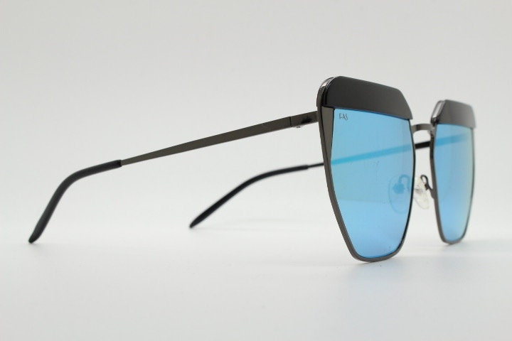 For Arts Sake angular cat eye hand made sunglasses. Black flat top 'eyebrow' design with blue mirror lenses and gunmetal grey frame