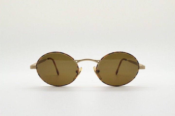 Armandos 90s vintage oval sunglasses made in Italy. Enamelled honey tortoise front with ornate tooled metal arm patterns. NOS