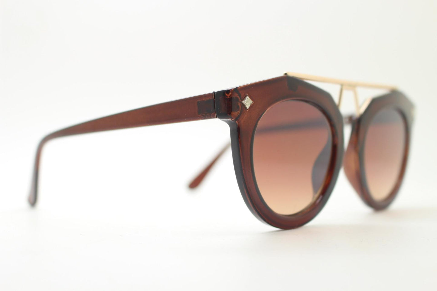 Rounded cateye sunglasses with gold 'scaffold' metal bridge. Women's transparent frame with matching brown graduating lenses. Vintage NOS