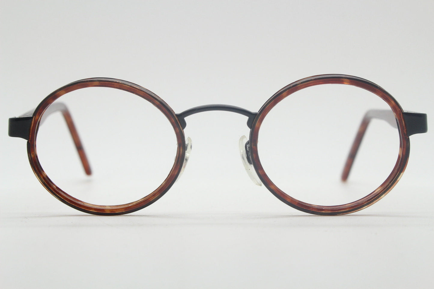 90s vintage oval glasses. Minimal slim black optical frame encasing tortoise inserts. 40s, 50s style prescription eyeglasses. RX spectacles
