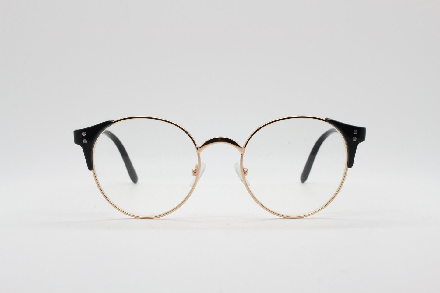 90s vintage modified cat eye glasses. Black arms with a round gold face. 40s, 50s style clear lens eyeglasses. Cateye