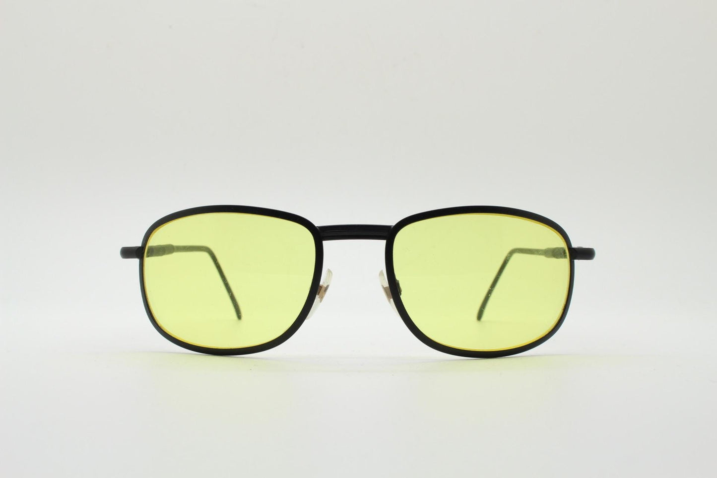 90s vintage oval bug eye sunglasses. Matt black metal frame with blazing yellow lenses and ingenious temple springs. 2000s. NOS