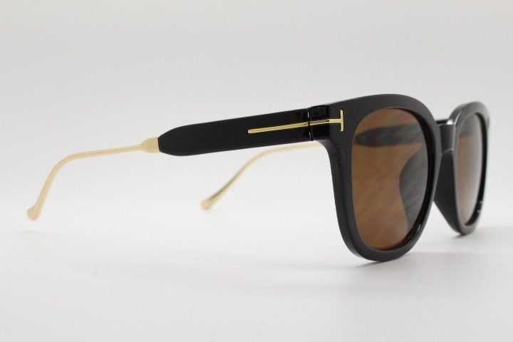 Tom Ford vintage wayfarer design sunglasses made in Italy. Slightly cat eye form in plain black gloss acetate with gold arms