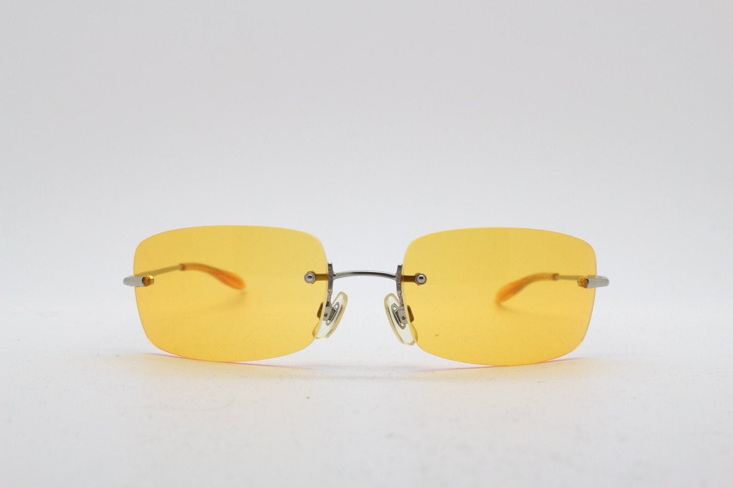 Y2K vintage frameless orange sunglasses. Rectangular wrap around lenses with satin silver bridge and arms. 2000s club kids. 00's. 90s. NOS