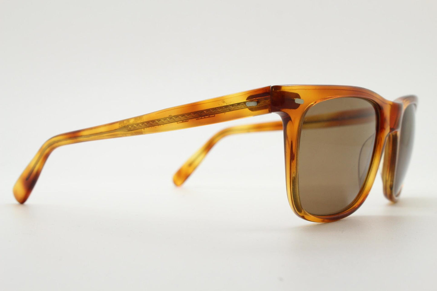 Uomo vintage 90s wayfarer design sunglasses made in Italy. All time classic format in mottled amber frame with contrasting brown lenses. NOS