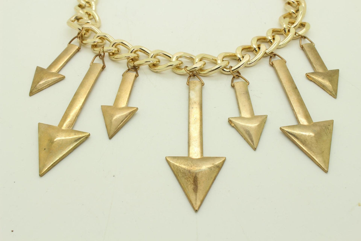 80s vintage massive arrows on a chain necklace. Bombastic golden shiny metal arrows in different sizes on a chunky fat chain. Hip Hop