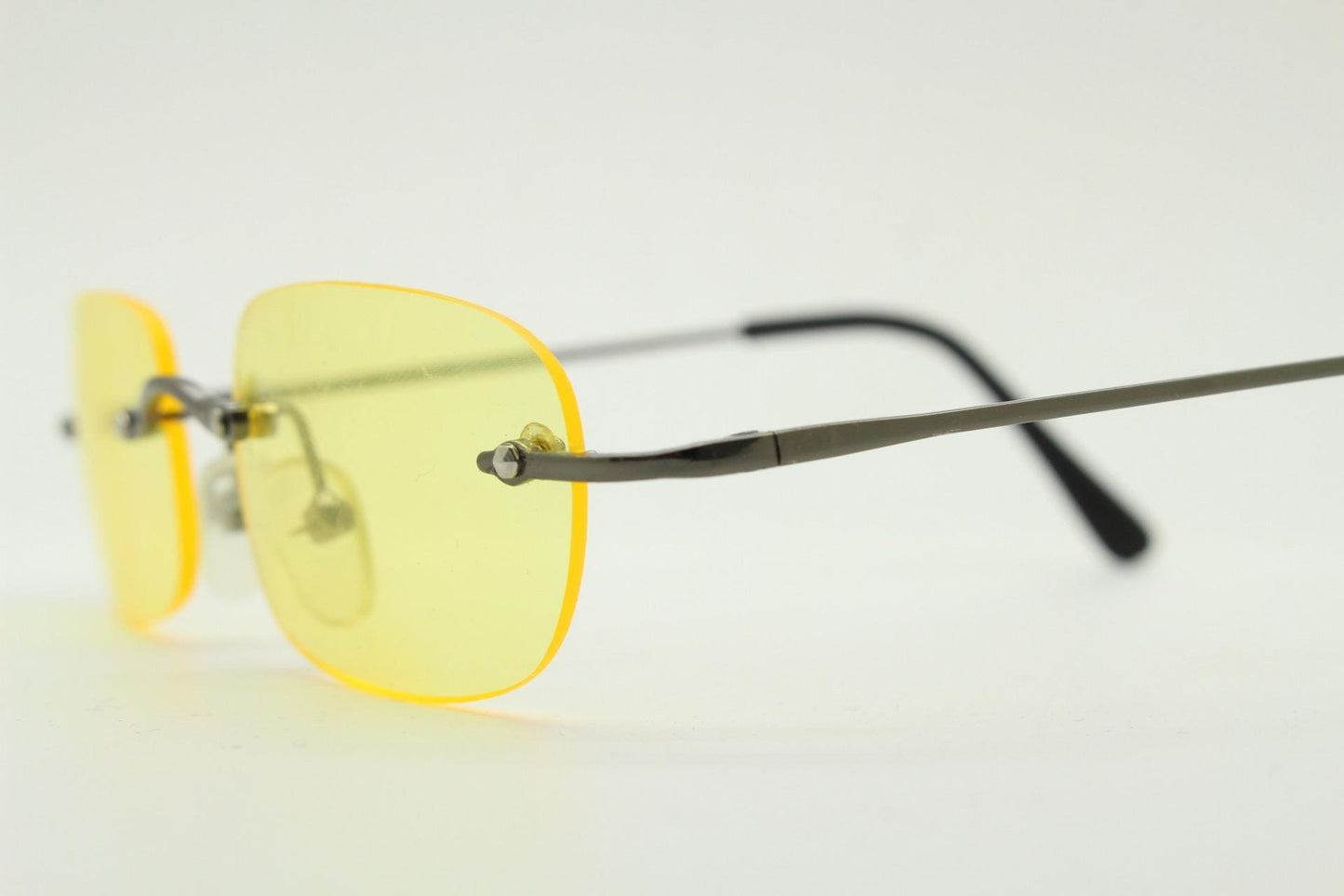 Y2K vintage frameless yellow sunglasses. Rectangular lenses with grey metal bridge and arms. 2000s club kids. 00's. 90s Rave