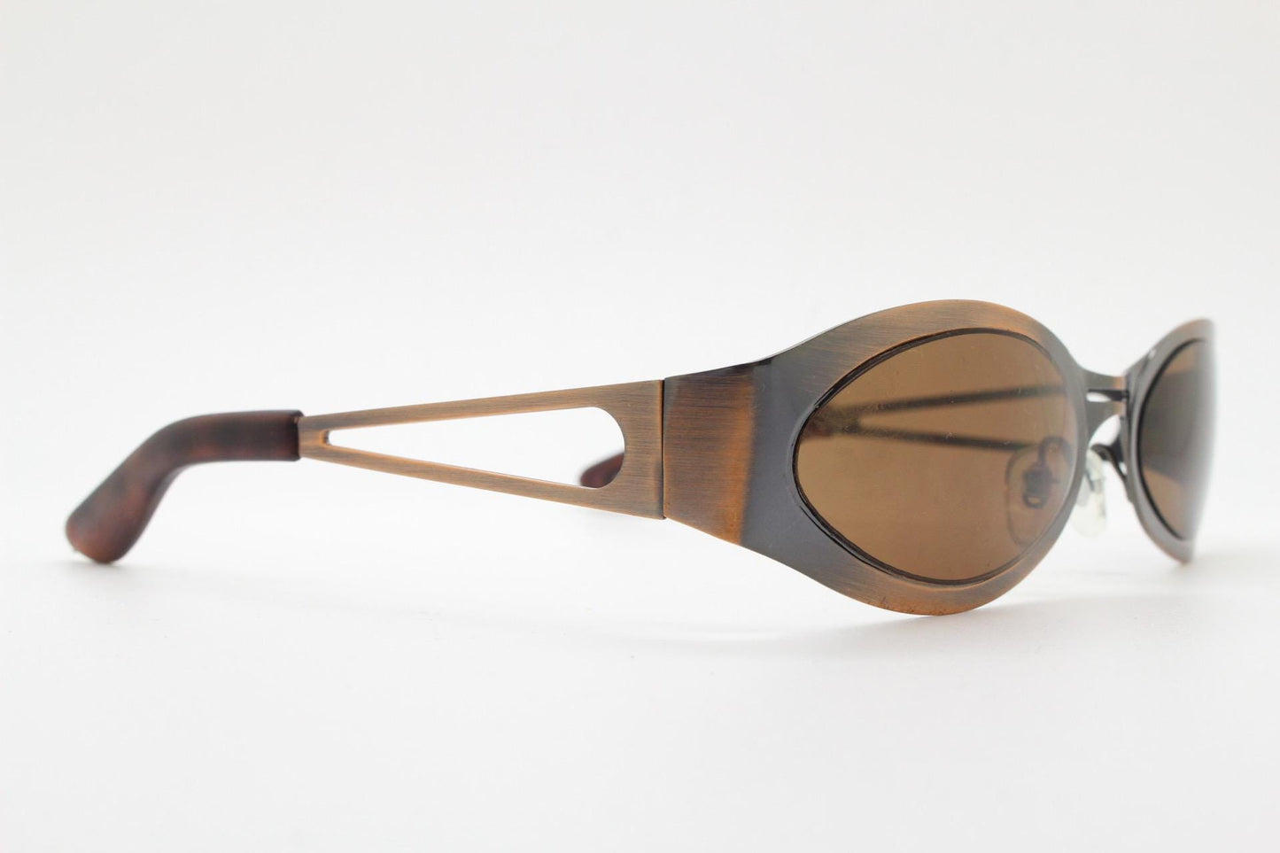 2000s vintage wraparound angular sunglasses. brushed copper finish flat curved metal frame with cut out arms. 90s. Y2K unused NOS