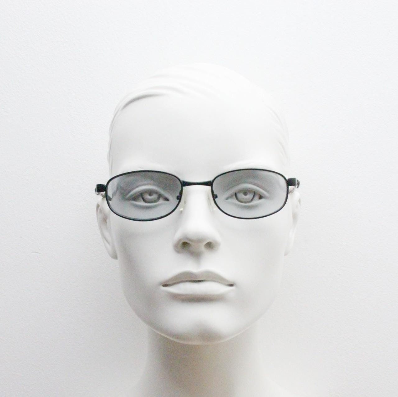 90s vintage oval small bug eye sunglasses. Curved black satin finish metal frame with transparent grey arms and light tone lenses. NOS