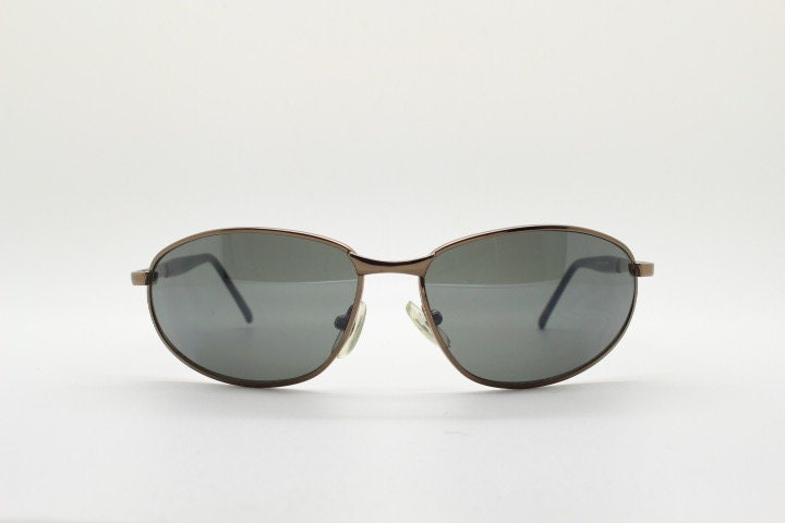 Y2K vintage small bug eye sunglasses. Curved brown chrome metal frame with black arms. Unused 2000s NOS