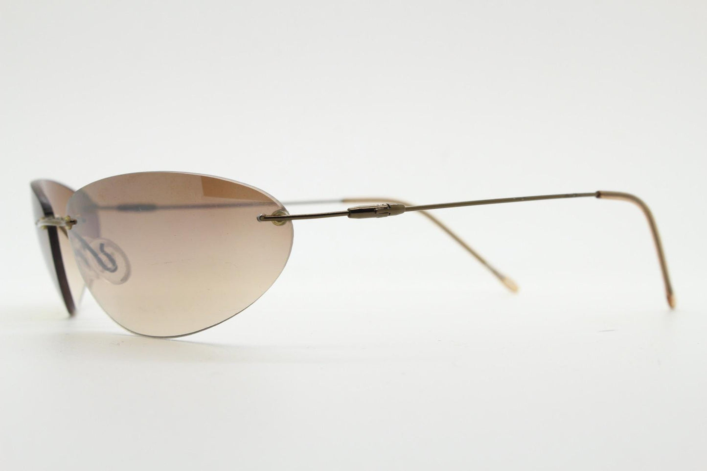90s vintage frameless oval wraparound sunglasses. Minimal curved almond shaped lenses with brown chrome arms. 2000s NOS. Matrix cosplay