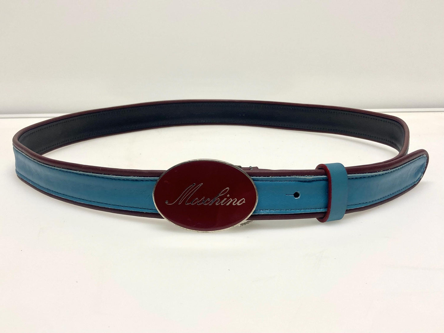 Moschino 90s vintage womens dress belt in oxblood and blue genuine leather with oval enamelled metal buckle. Made in Italy. BNWT. NOS