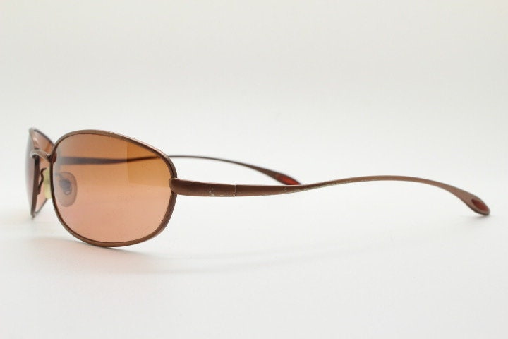 Y2K vintage oval small bug eye sunglasses. Curved copper satin finish metal frame with slender arms. Unused 2000s NOS