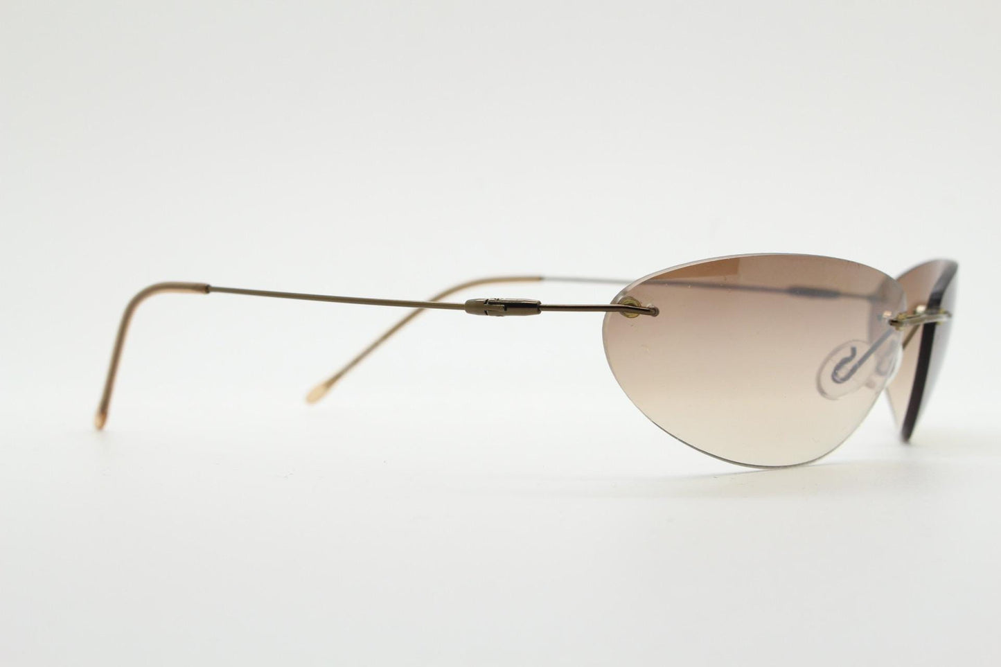90s vintage frameless oval wraparound sunglasses. Minimal curved almond shaped lenses with brown chrome arms. 2000s NOS. Matrix cosplay