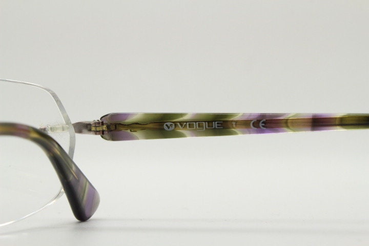 Vogue vintage frameless oval eye glasses. Transparent acetate arms with purple and green tones. Minimal Prescription RX Optical frame