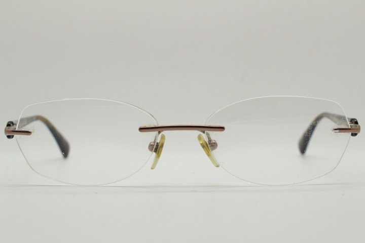 Vogue vintage frameless oval eye glasses. Transparent acetate arms with purple and green tones. Minimal Prescription RX Optical frame