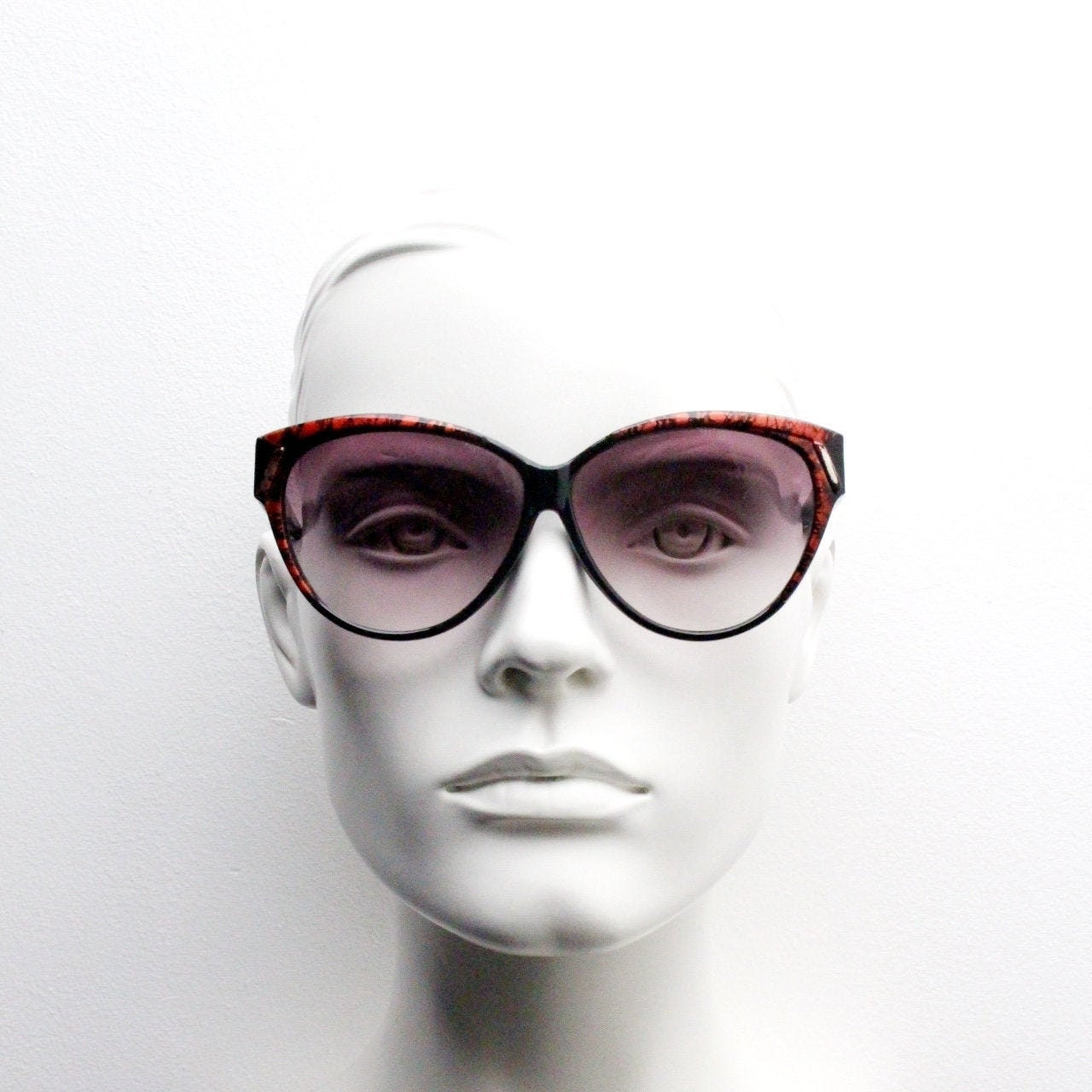 80s vintage oversized cateye sunglasses. Women's black cat eye frame with red patterned brow and sizzling gradient lenses