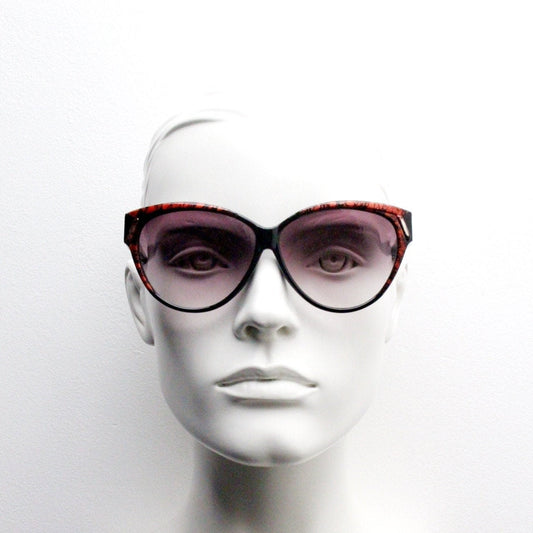 80s vintage oversized cateye sunglasses. Women's black cat eye frame with red patterned brow and sizzling gradient lenses