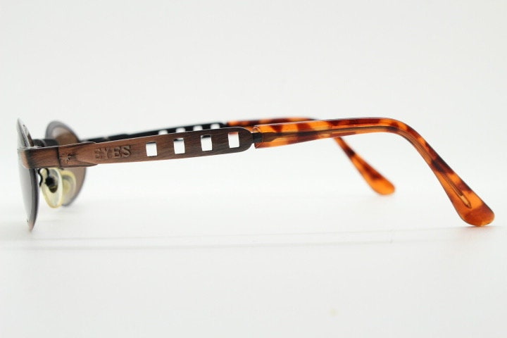 90s vintage oval sunglasses. Handsome metallic brushed copper finish with arm cut outs. Unused NOS