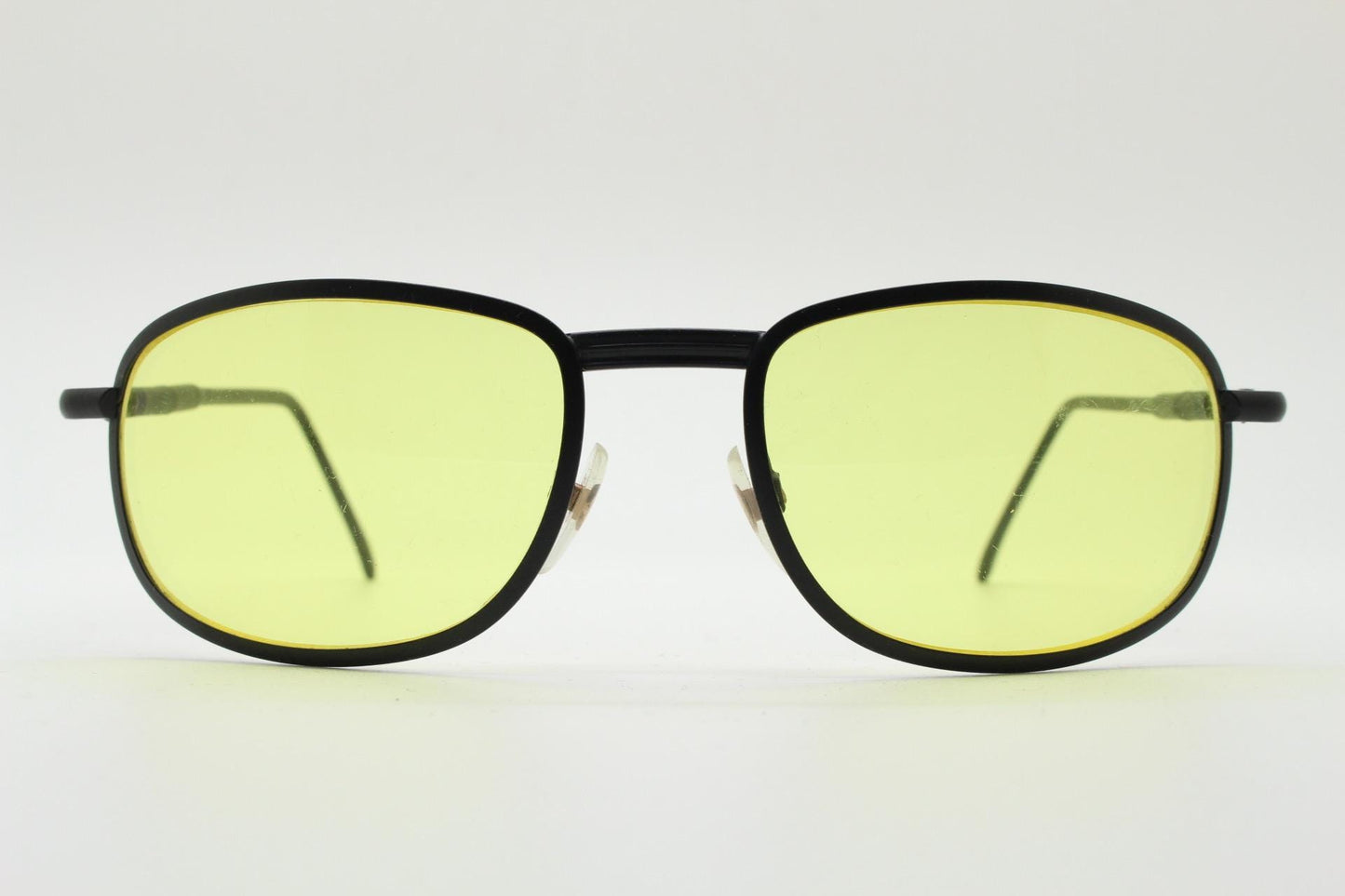 90s vintage oval bug eye sunglasses. Matt black metal frame with blazing yellow lenses and ingenious temple springs. 2000s. NOS