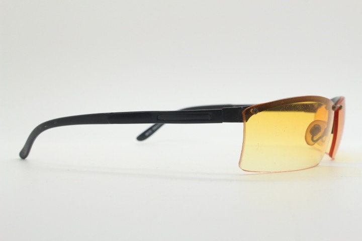 Y2K vintage half frame visor sunglasses. 2000's black brow line with light tone blazing orange rectangular curved lenses. 00's