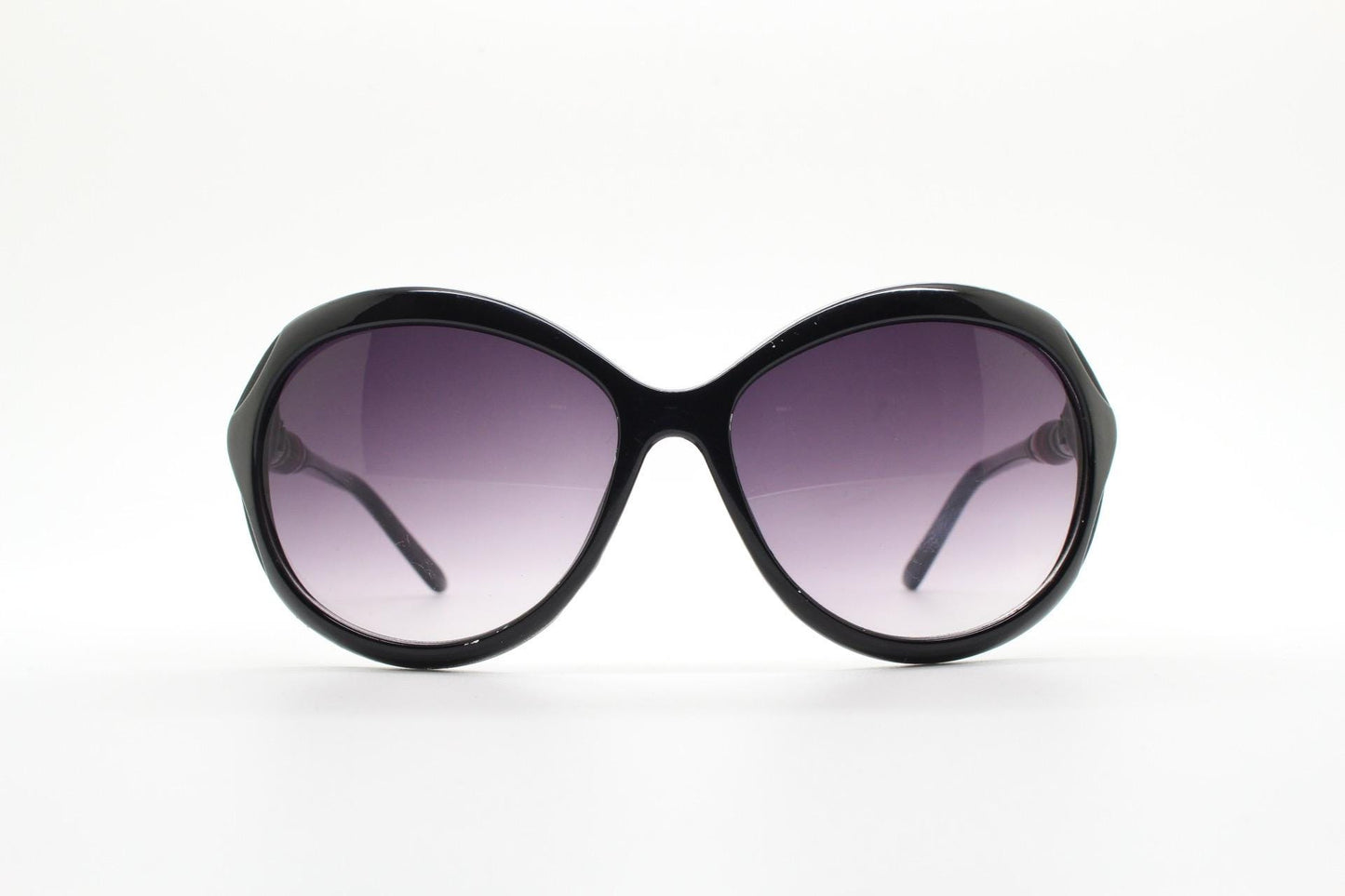 Y2K vintage big round sunglasses. Women's classical 60s design in black gloss with graduating lenses and subtle arm detail. 2000s. 00s NOS