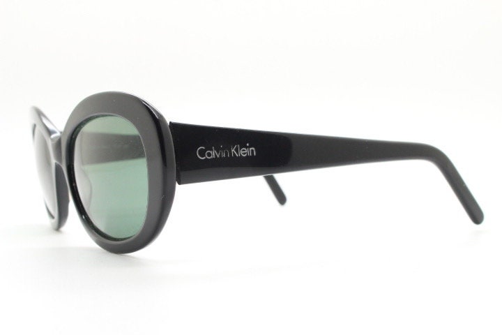 Calvin Klein vintage oval cateye sunglasses made in Italy. Womens plain black gloss thickened acetate cat eye. Classical 60s design. Y2K