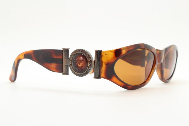 90s vintage oval sunglasses. Low profile transparent tortoise frame with massive bronze metal arm crests BNWT. Unused NOS