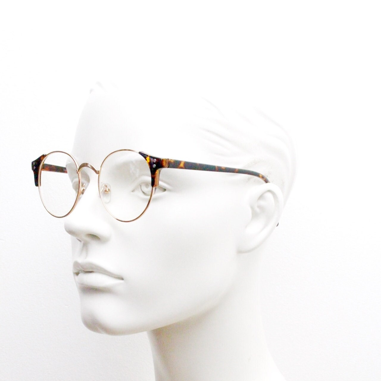 90s vintage modified cat eye glasses. Tortoise arms with a round gold face. 40s, 50s style clear lens eyeglasses. Cateye