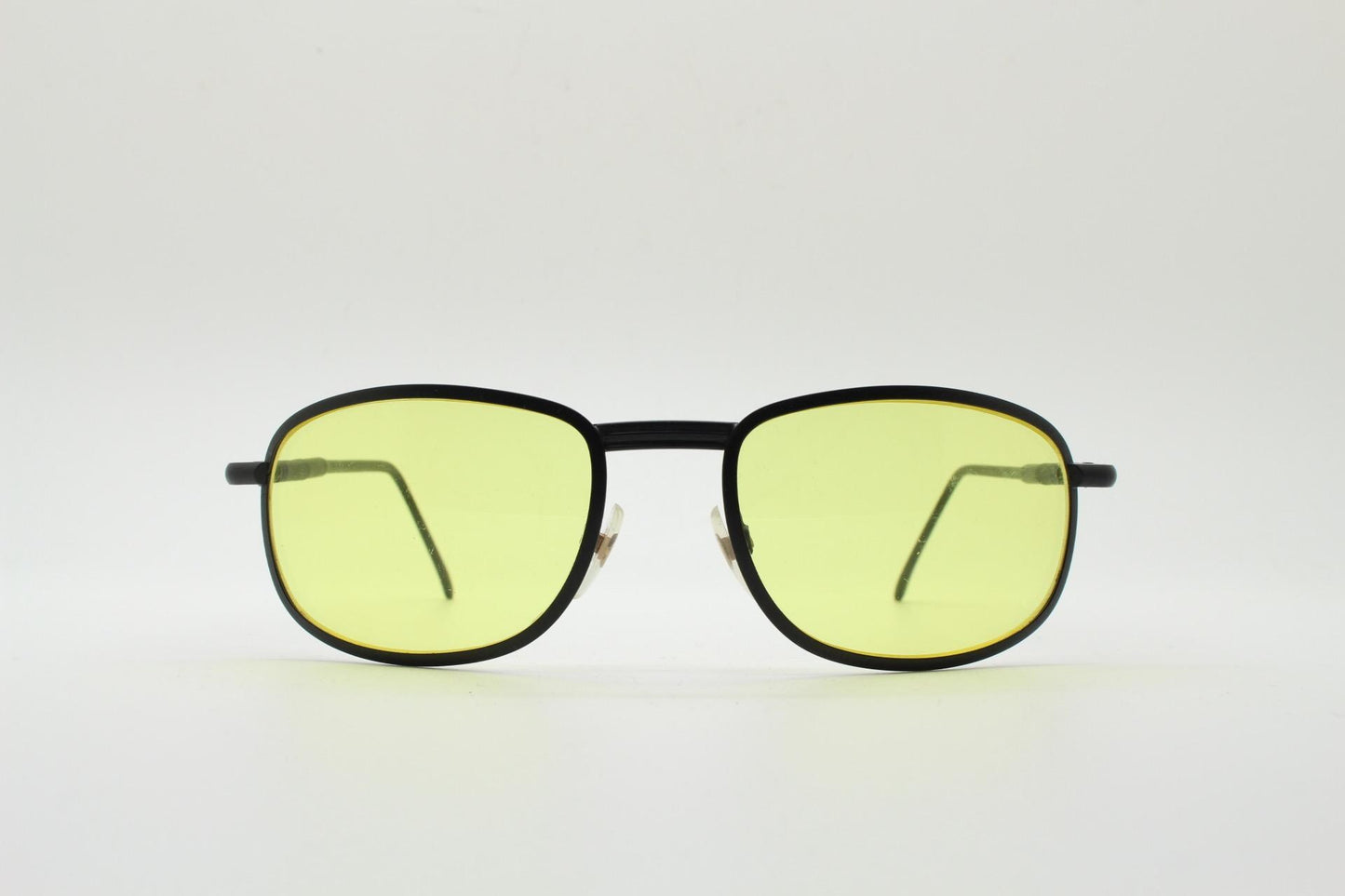 90s vintage oval bug eye sunglasses. Matt black metal frame with blazing yellow lenses and ingenious temple springs. 2000s. NOS