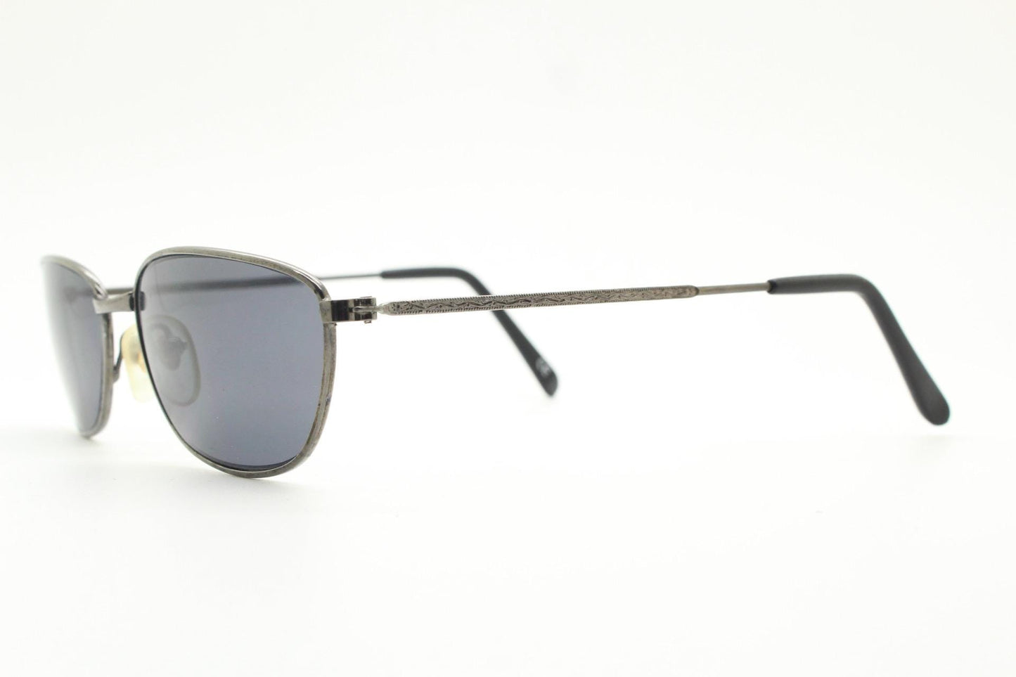 90s vintage angular pointed sunglasses. Minimal grey chrome metal frame with embossed patterned arms. Subtle cat eye. NOS