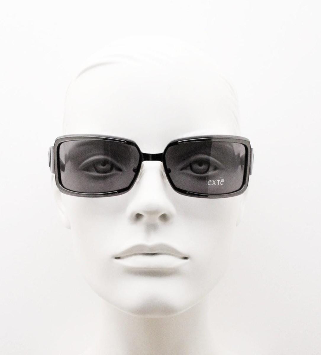 Exte wrap around 90s vintage sunglasses made in Italy. Grey metal front with black acetate arms and curved lenses in neat proportions. BNWT