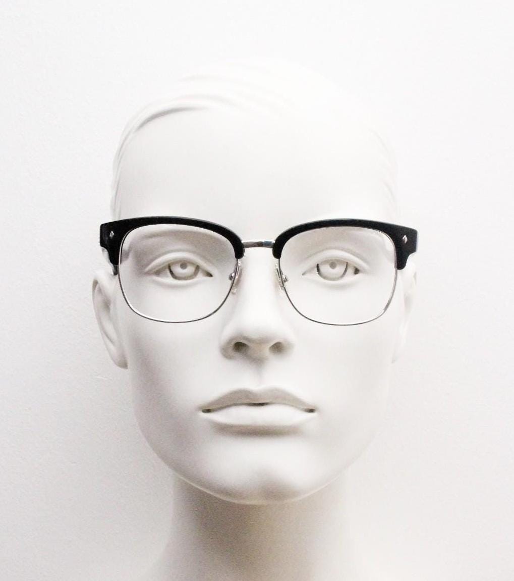 A mannequin head wearing black-framed glasses against a plain white background.