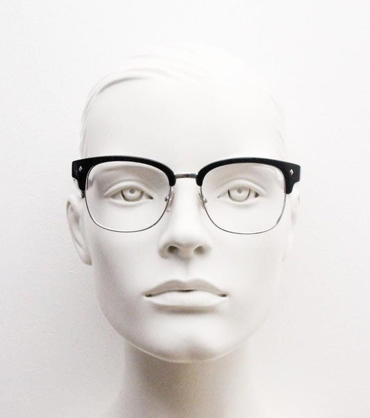 A mannequin head wearing black-framed glasses against a plain white background.