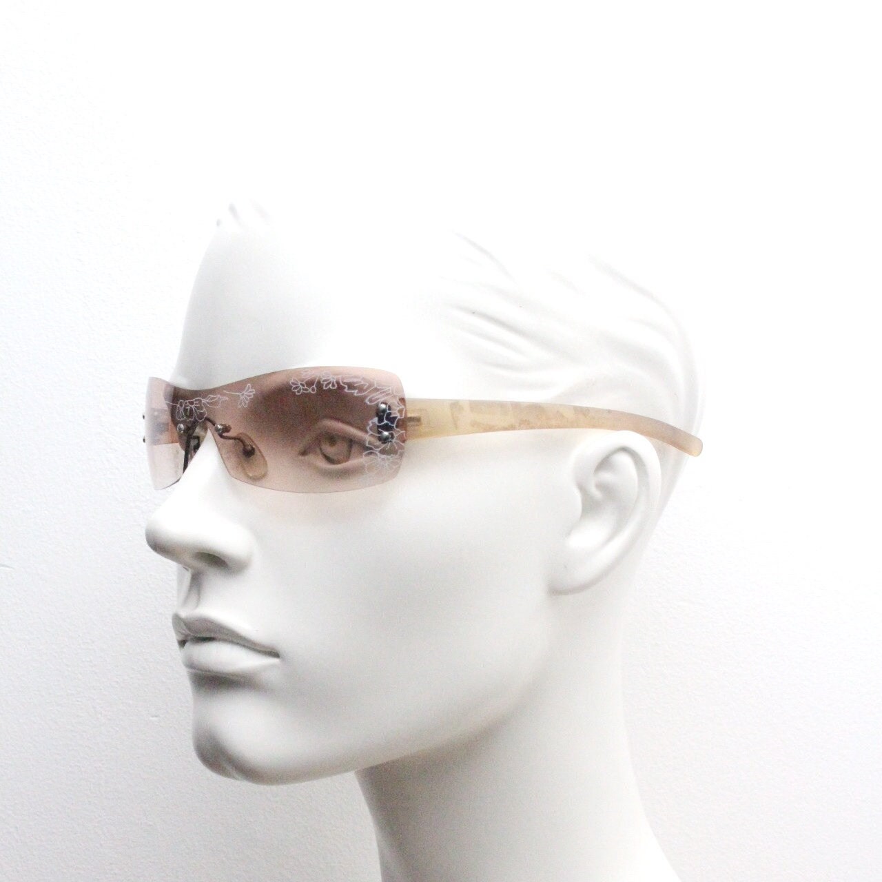Y2K vintage visor sunglasses. Frameless 2000's wraparound mini mask shield design with light tone mono lens and flower print. 00s NOS