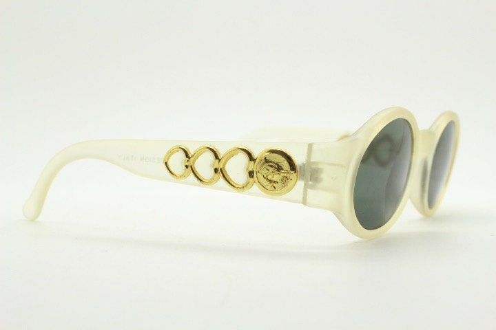 Vintage 90s oval transparent sunglasses. Frosted frame with dark green lenses and heart shaped chain link arms. Unworn NOS