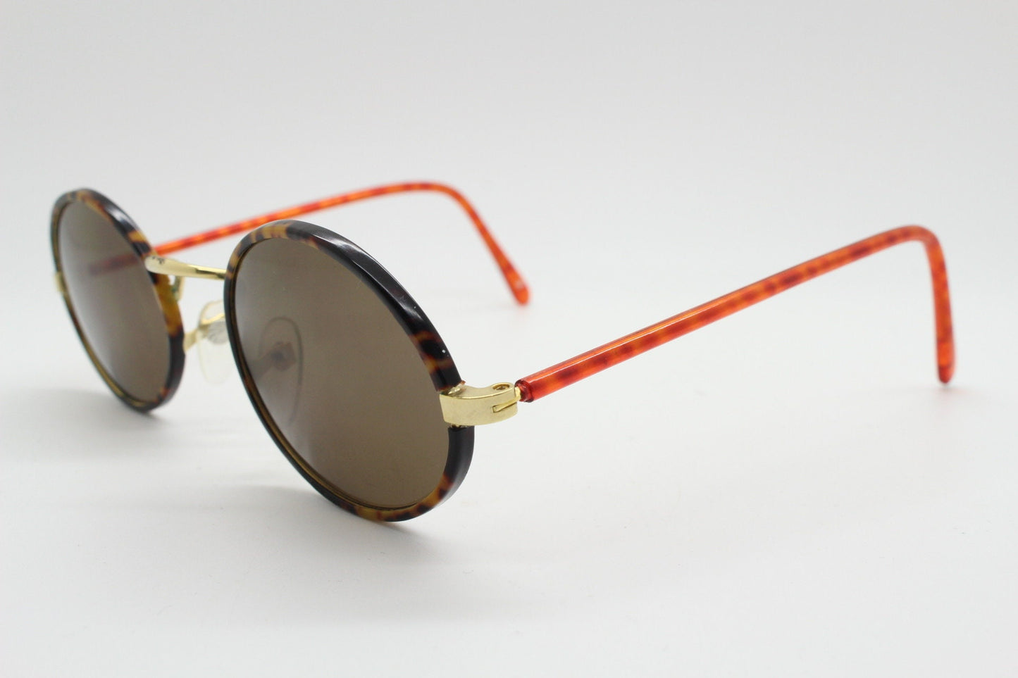 90s vintage oval sunglasses. Handsome honey tortoise and blazing amber arm combo on a slender metal frame. NOS