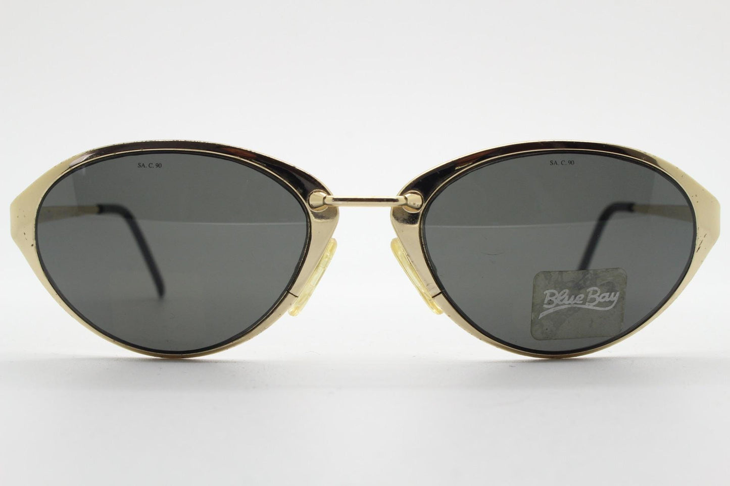 Blue Bay 90s vintage oval cat eye sunglasses made in Italy by Safilo. Dynamic gold chrome finish with contrasting dark lenses. NOS with tag