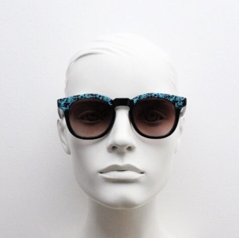 80s vintage rounded wayfarer design sunglasses. Abstract patterned blue brow and arms on a black frame with graduating  lenses. Unused NOS