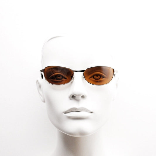 90s vintage curved angular oval sunglasses. Solid metal small bug eye frame in gold chrome with mid tone brown lenses. 2000's. Y2K NOS